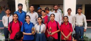 Students and a teacher posing with trophies.
