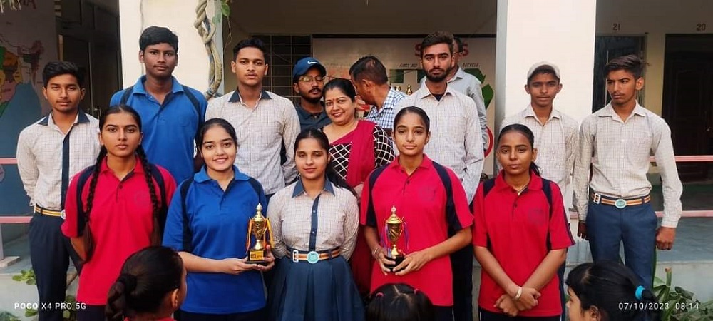 Students and a teacher posing with trophies.
